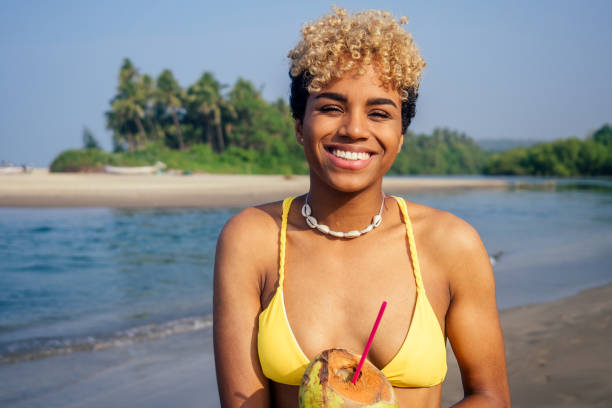 istock hispanic latin beautiful female drinking coco nut water seashells on the neck 1399150826