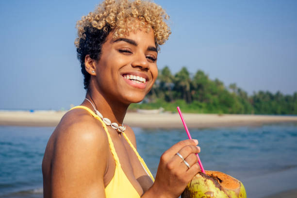 istock hispanic latin beautiful female drinking coco nut water seashells on the neck 1399150833