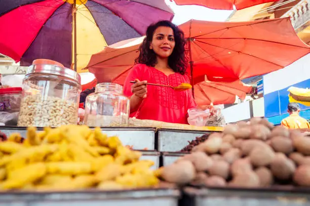indian happy woman salling spices in bazaar in Goa .