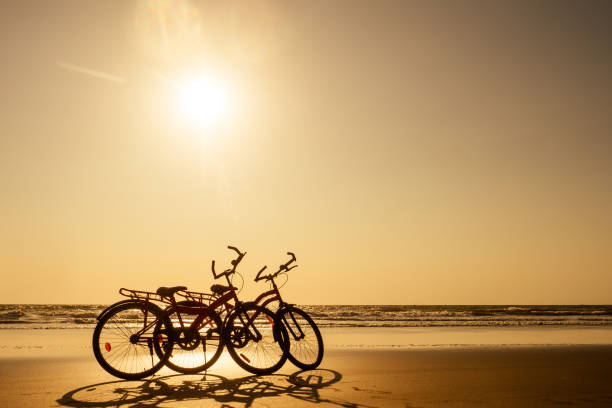 two bicycles and empty beach without people.no body at sunset .