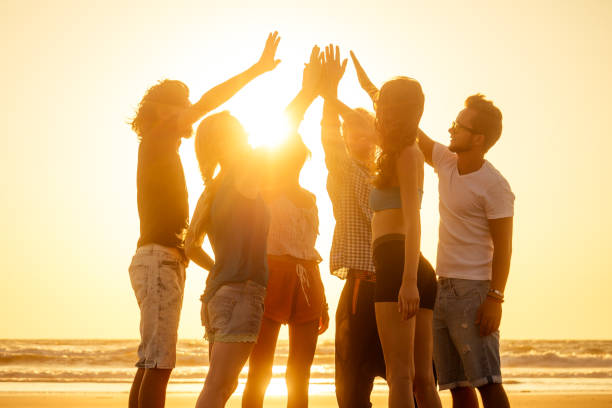 istock young multiethnic group of friends having fun on the beach when outbreak covid spreading is in the air high five 1399151404