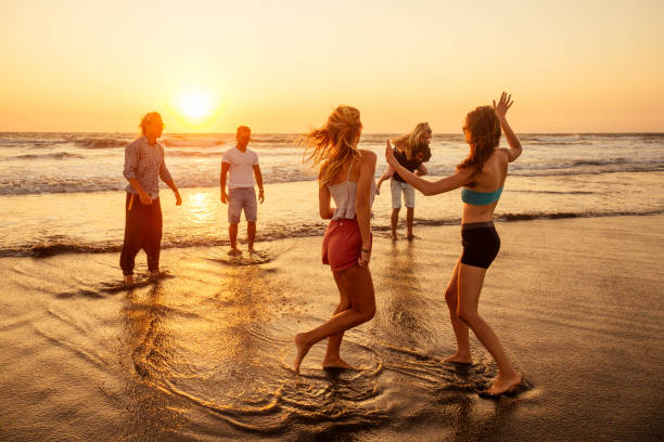multicultural multinational happy people running into the sun carefree and happiness, vacation on sea stock photo