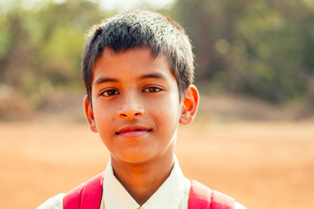 indian smart boy arms crossed looking at camera in backyard.