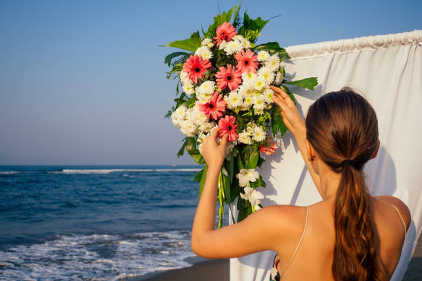 istock Decorator working with flowers composition for wedding arch on ocean beach 1399151848