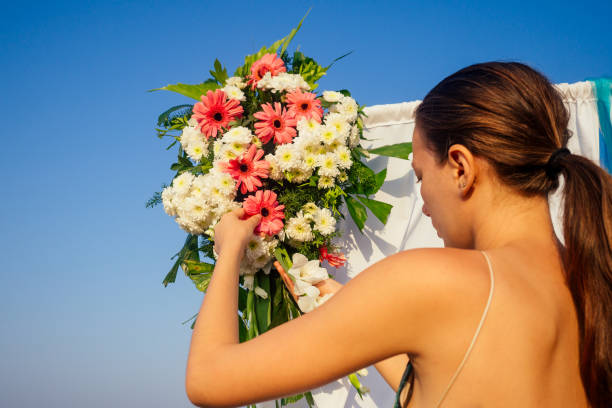 istock Decorator working with flowers composition for wedding arch on ocean beach 1399151852