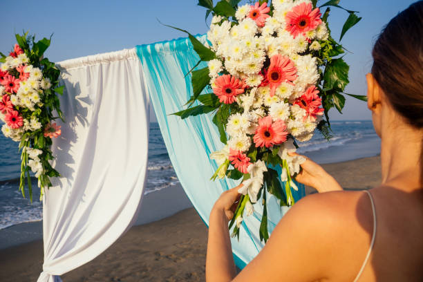istock Decorator working with flowers composition for wedding arch on ocean beach 1399151853