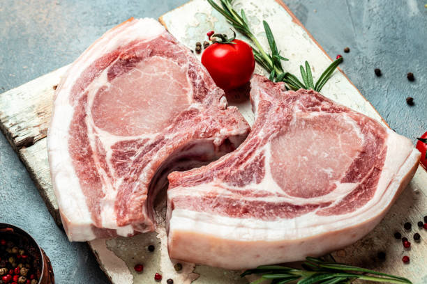 istock raw pork chop steak. Organic food. vertical image. top view. place for text 1399151913