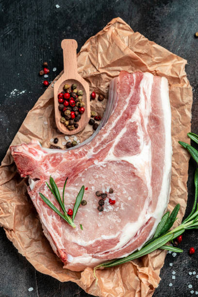 istock raw pork chop steak. Organic food. vertical image. top view. place for text 1399151931