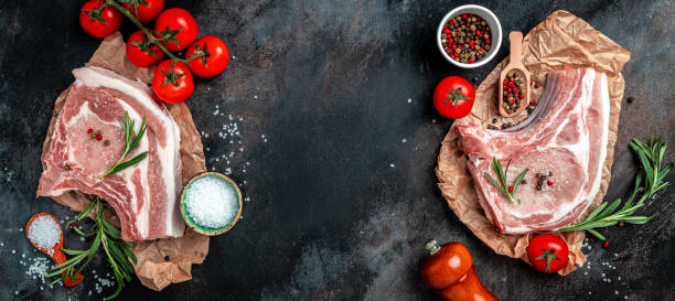 istock Fresh raw pork meat with ingredients ready for cooking on black table. Long banner format. top view 1399151945