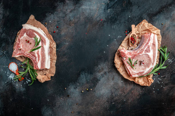 istock barbecue pork portion set on dark table. Pork meat chop set with herbs and ingrefients. banner, menu, recipe place for text, top view 1399151948