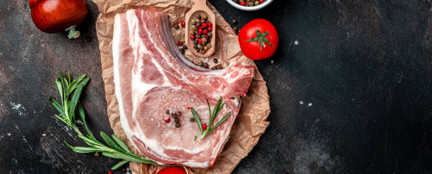istock raw pork chop steak. sliced raw pork meat. Long banner format. top view 1399151952