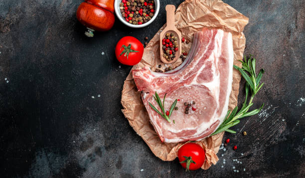 istock Appetizing raw pork steak in pan is ready for frying. chop on a bone. place for text, top view 1399151961