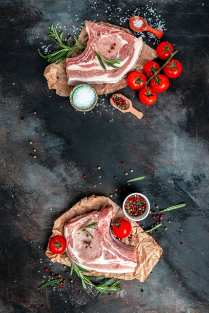 istock fresh raw meat with spices and rosemary. pork, beef, chop on a bone. vertical image. top view. place for text 1399151974