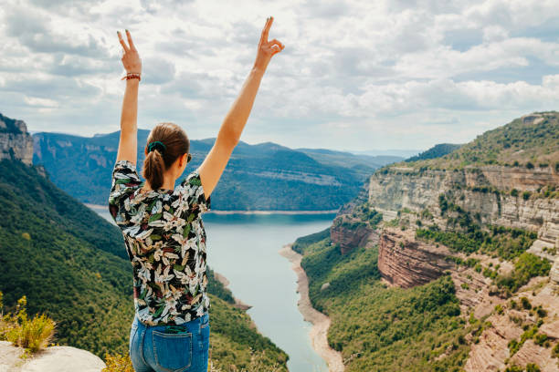 istock Rear view young hiker female standing with raised arms enjoying mountain 1399153321