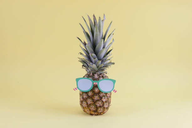 istock pineapple wearing glasses on yellow background 1399153356