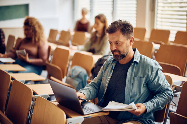 istock Mature man e-learning on laptop during a lecture at university classroom. 1399154858