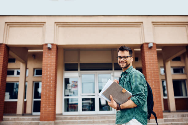 istock Happy student going to lecture at the university and looking at camera. 1399154924