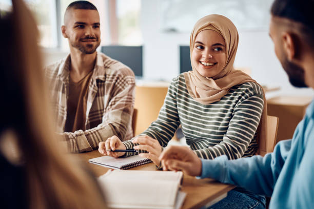 istock Happy  Muslim student talking to her classmates while learning together at college classroom. 1399156143