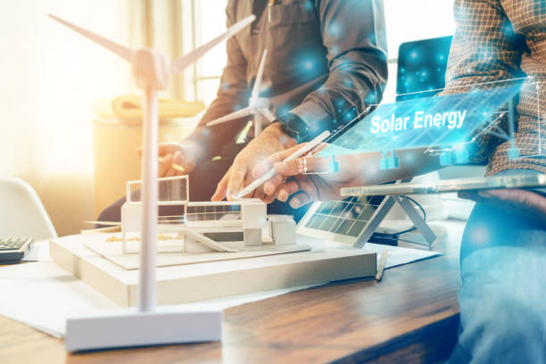 istock Architect team planning design apply renewable or solar energy on architectural building model with virtual reality technology hologram. 1399156745