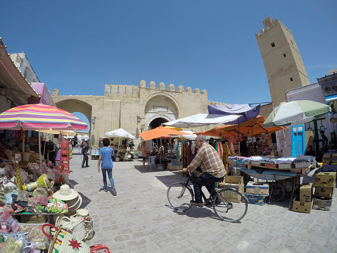 Hammamet, Tunisia: May 17, 2022: Tourists shop at the medina for souvenirs while locals buy essential products.