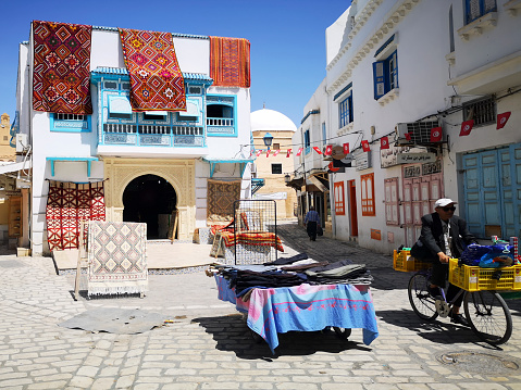 Hammamet, Tunisia: May , 2022: Tourists shop at the medina for souvenirs while locals buy essential products.