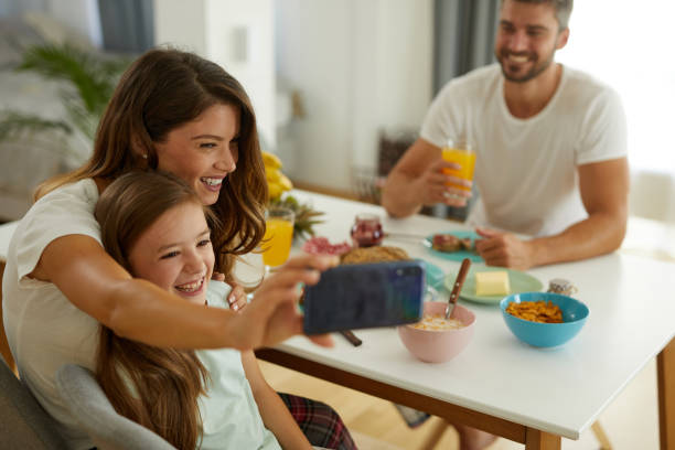 istock Mother and daughter taking Selfie during breakfast at home 1399161922