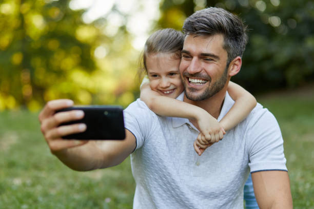 istock Father and daughter taking Selfie in the park 1399161943