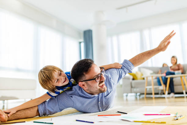 istock Playful father and son having fun on floor at home. 1399162040