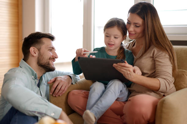 istock Happy parents and their daughter using digital tablet at home 1399162904