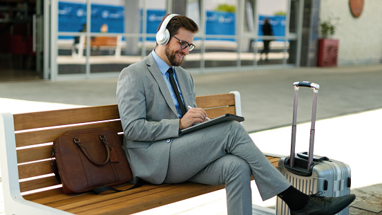 Businessman using digital tablet at train station