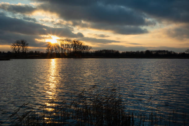 istock Sunset with clouds over a calm lake 1399166610