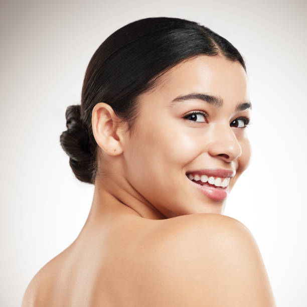 istock Face of a young beautiful mixed race woman smiling and posing against a grey studio background. Content hispanic female posing against a background 1399167708