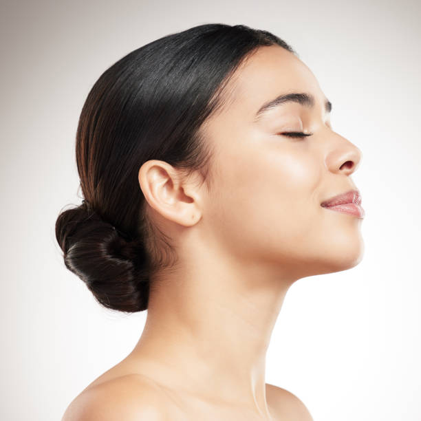 istock Side of a young beautiful mixed race woman’s face smiling and posing against a grey studio background. Content hispanic female posing against a background 1399167709
