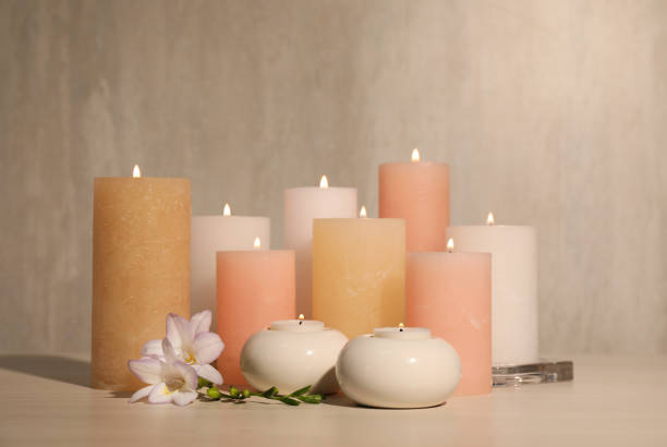 istock Burning candles and beautiful flowers on wooden table 1399168030