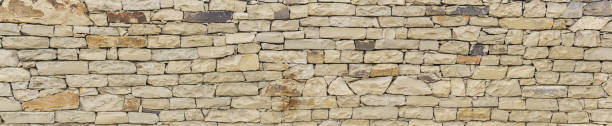 istock horizontal background, texture - wall of roughly hewn natural light stone 1399169382