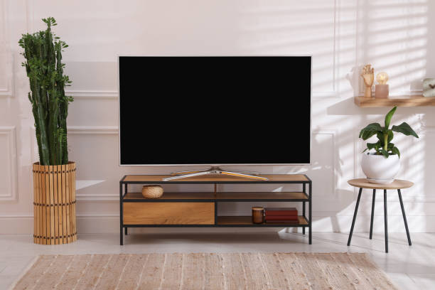 istock Modern TV on stand near white wall indoors. Interior design 1399169747