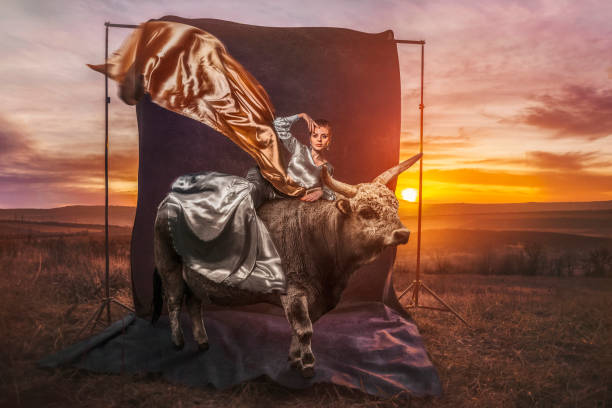 Beautiful woman with bull in sunset