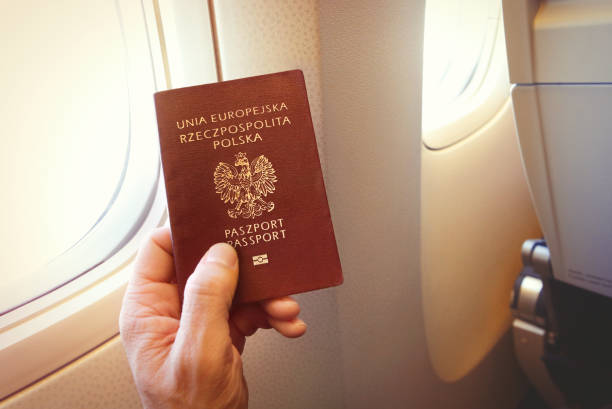 Detail of passenger's hand holding Polish passport  on the airplane