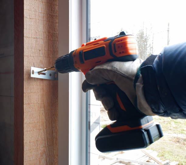istock installation of plastic in a frame house, the builder screws the window frame to the slopes with a screwdriver 1399172067