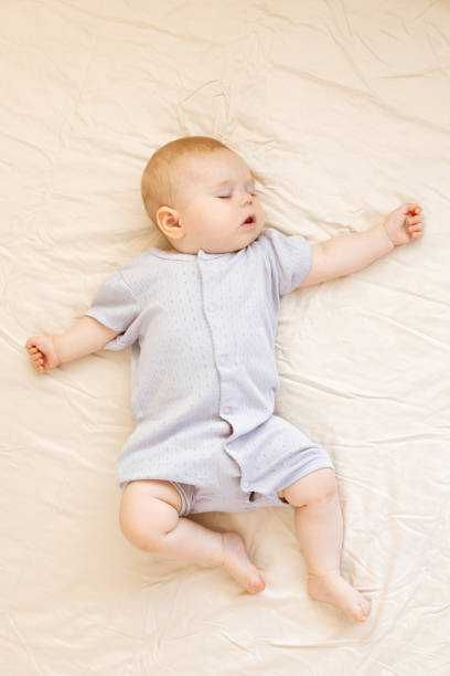 Peaceful baby lying on a bed and sleeping at home