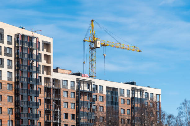 istock high-rise construction crane and unfinished monolithic building on the blue sky background. The construction of modern apartment 1399172539