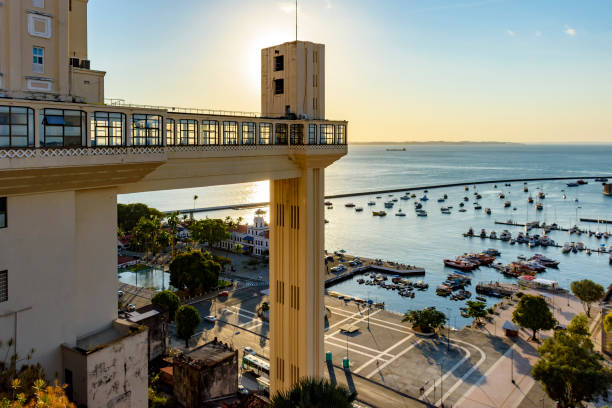 Sunset in the city of Salvador behind the Lacerda elevator Sunset in the city of Salvador behind the Lacerda elevator with the Bay of All Saints and its boats in the background lacerda elevator stock pictures, royalty-free photos & images
