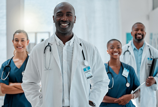 Group of happy doctors and nurses standing in a line with their arms crossed while working at a hospital. Content expert medical team smiling at work together at a clinic