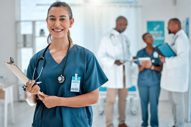 ritratto di una dottoressa di razza mista che tiene in mano un blocco appunti che lavora in un ospedale con i colleghi. professionista medico esperto ispanico sorridente pronto per il lavoro in una clinica con i colleghi - paramedico foto e immagini stock