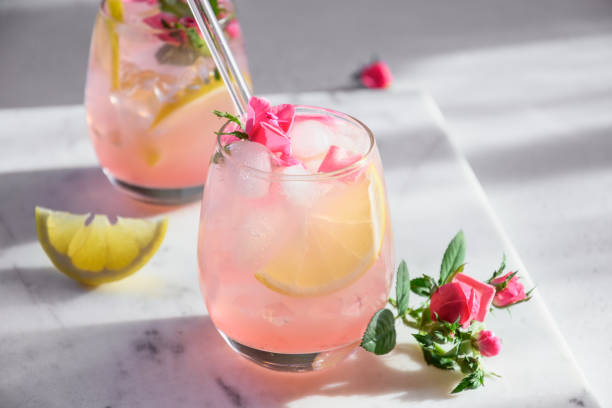 freshness pink lemonade with rose gin garnish lemon in sunny shadow. - pink champagne fotos imagens e fotografias de stock