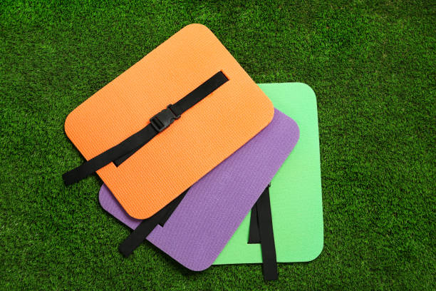 istock Bright foam tourist seat mats on green grass, flat lay 1399177046