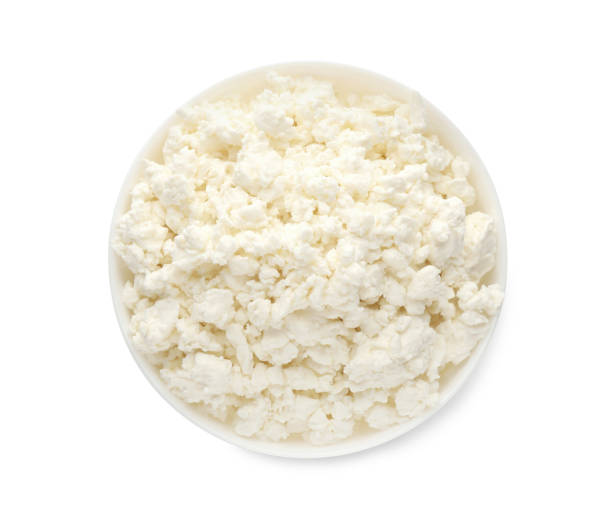 istock Delicious fresh cottage cheese in bowl isolated on white, top view 1399177581