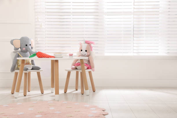 istock Cute toys at table with crockery indoors 1399177866