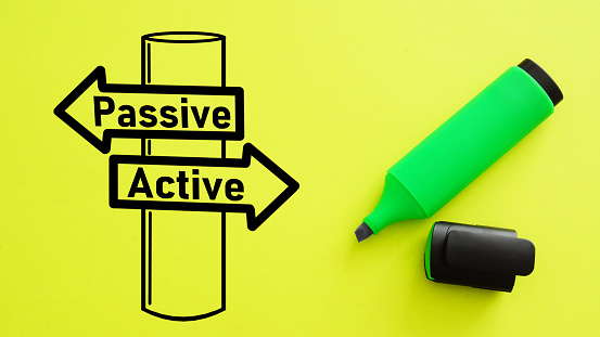 Passive - Active income signpost drawn on a yellow background. Active investing vs passive investing pros and cons