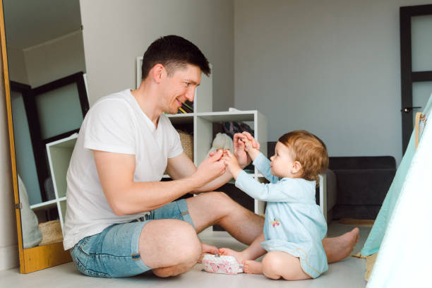 istock Brunette father spent time playing with daughter taking hands together and look each other 1399178894
